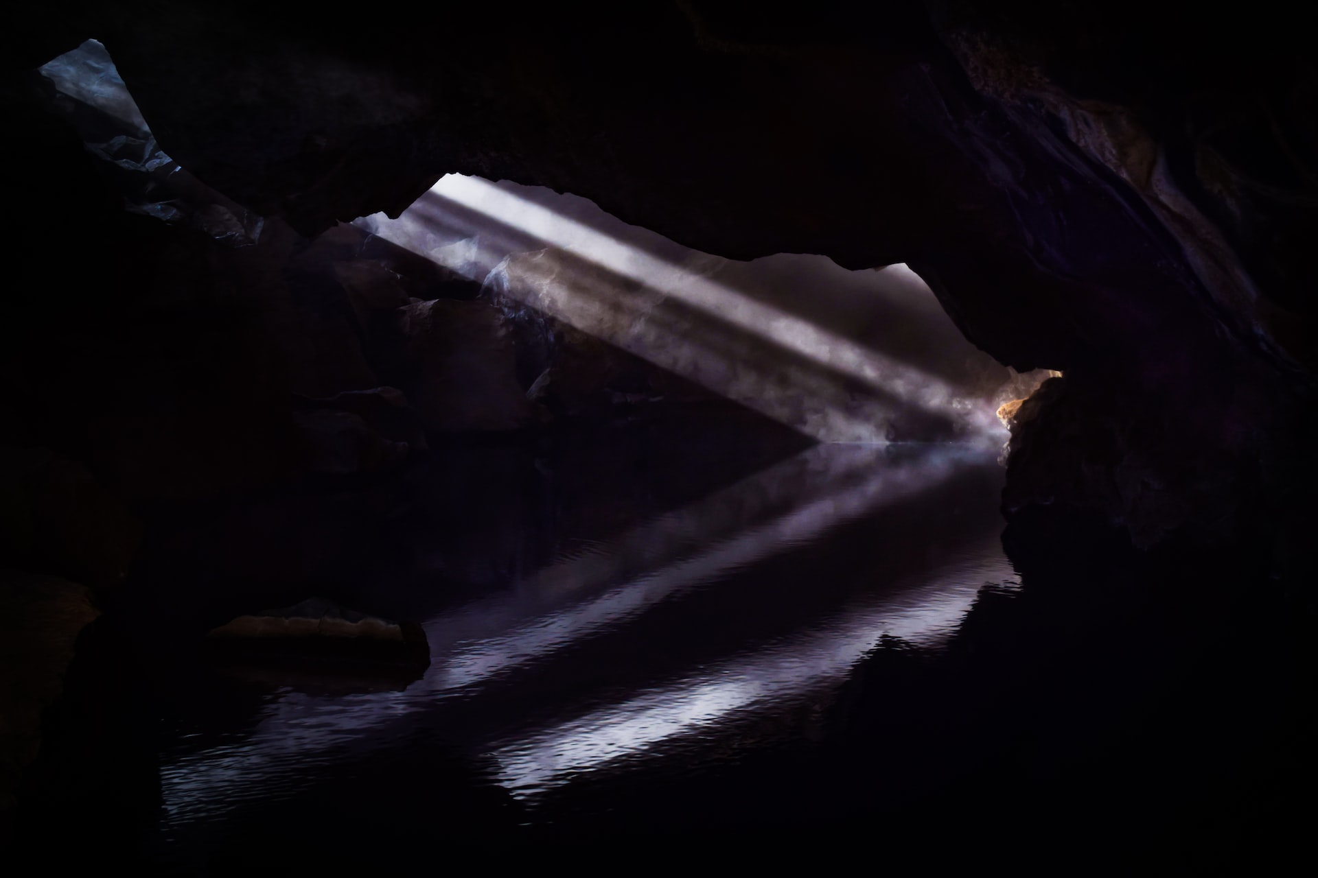 Beams of light in a cave, reflected in water